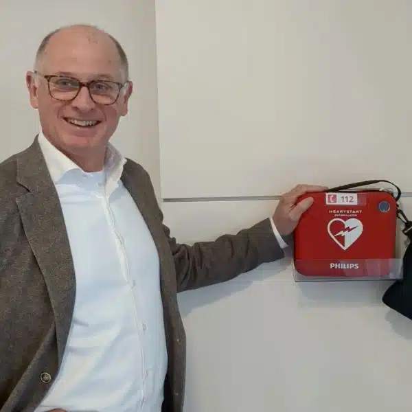 Mann montiert AED in Büro oder Flur